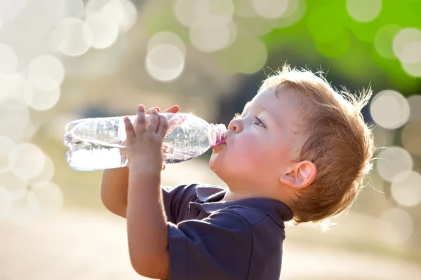 Hermosa rubia niño beber agua al aire libre — Foto de Stock