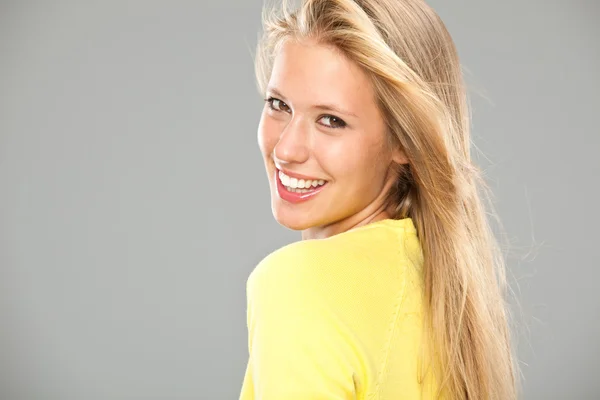 Hermosa chica rubia sonriente con camiseta amarilla isoated en gris —  Fotos de Stock