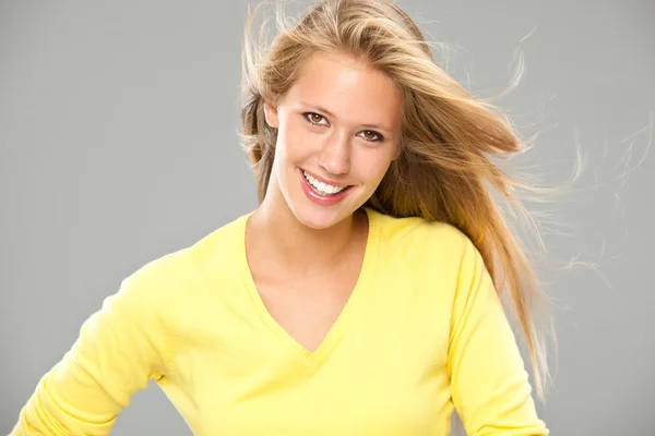 Bela loira sorridente menina com amarelo t-shirt isoated no cinza — Fotografia de Stock