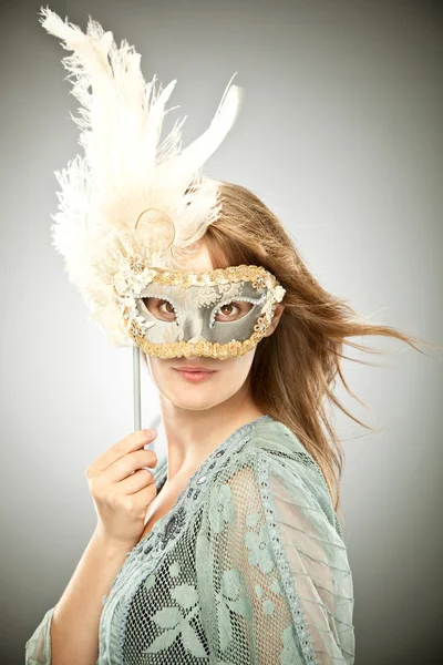 Красивая блондинка со старой карнавальной маской, изолированной на сером — стоковое фото