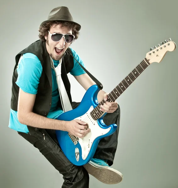 Funny guitar player in concert isolated on grey — Stock Photo, Image