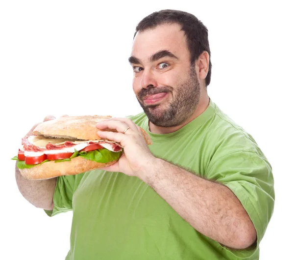 Толстый смешной человек ест огромный сэндвич изолирован на белом — стоковое фото