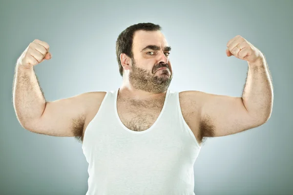 Смішний товстий чоловік мачо ізольований на сірому — стокове фото