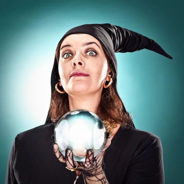 Witch or sorceress with hat and crystal ball on green background — Stock Photo, Image