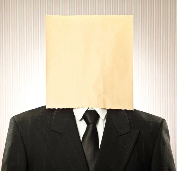 Conceptual businessman with paper bag on the head on vintage background — Stock Photo, Image