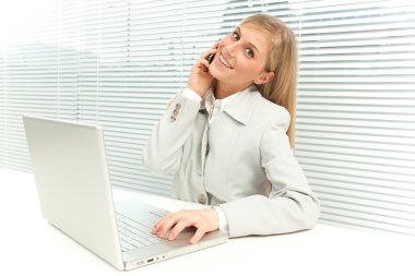 dizüstü konuşma telefonda yakınındaki jaluzi pencere ile sarışın iş kadını gülümseyen