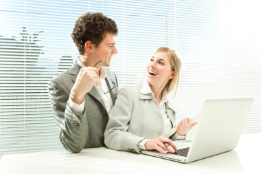 Jaluzi Perde pencere arka plan ile genç iş çift iş dizüstü bilgisayar