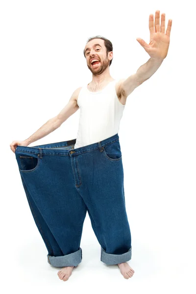 Divertente uomo magro con pantaloni grandi jeans isolati su bianco — Foto Stock