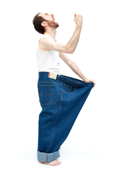 Lustiger schlanker Mann mit großen Hosen Jeans isoliert auf weiß — Stockfoto