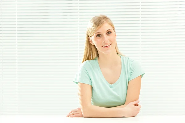 Beautiful casual blond woman in venetian window background — Stock Photo, Image