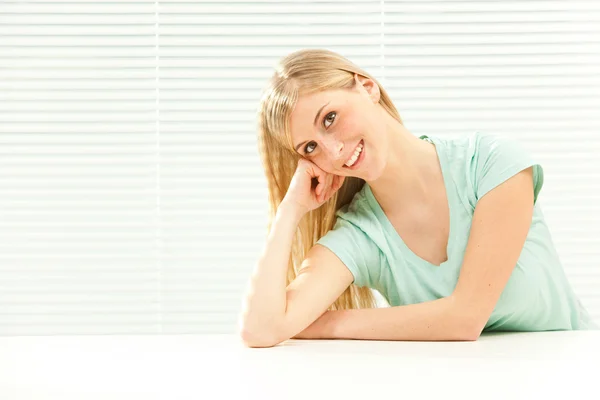 Beautiful casual blond woman in venetian window background — Stock Photo, Image