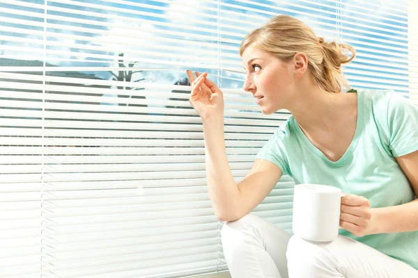 güzel rahat sarışın kadın içki fincan çay Venedik pencere arka planda