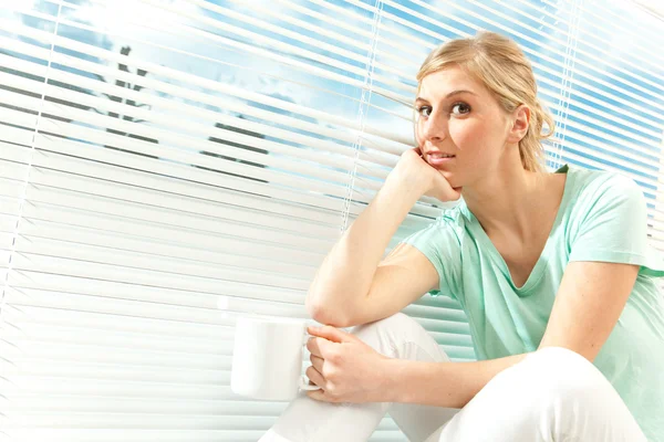 güzel rahat sarışın kadın içki fincan çay Venedik pencere arka planda