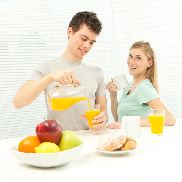 Young casual couple have breakfast with coffee and fruit with venetian blind window — Stock Photo, Image