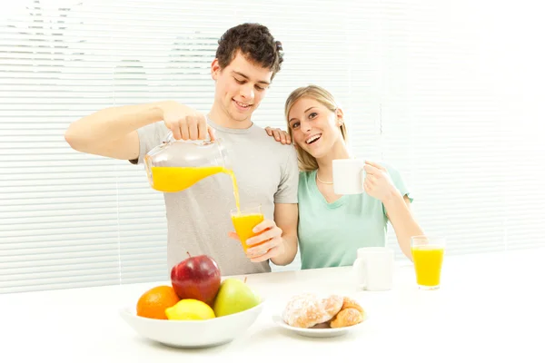 Young casual couple have breakfast with coffee and fruit with venetian blind window — Stock Photo, Image