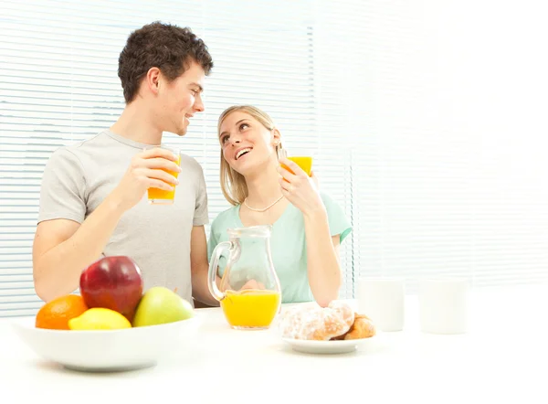 Jeune couple décontracté prendre le petit déjeuner avec café et fruits avec fenêtre aveugle vénitienne — Photo