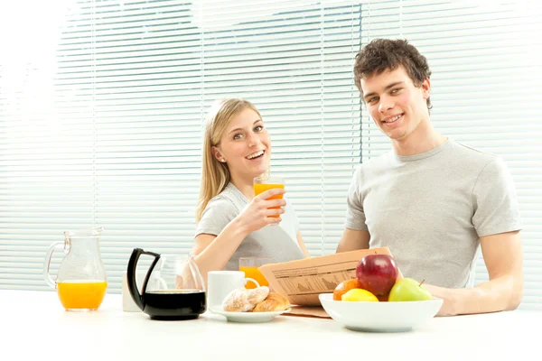 Junges Paar frühstückt mit Kaffee und Obstzeitung mit Jalousiefenster — Stockfoto