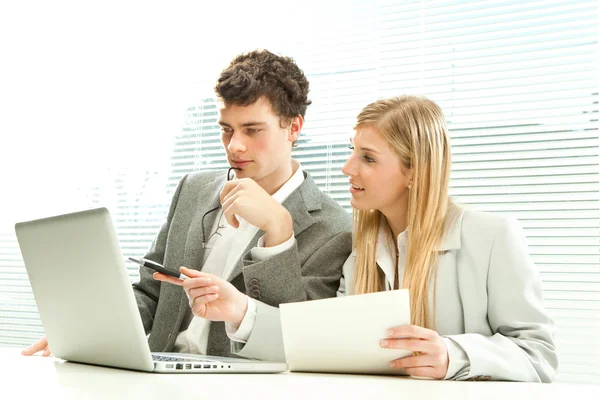 Giovane business coppia di lavoro laptop con veneziana finestra cieca sfondo — Foto Stock