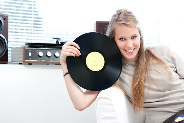 Joven hermosa mujer escuchar música con registro en una sala de estar —  Fotos de Stock