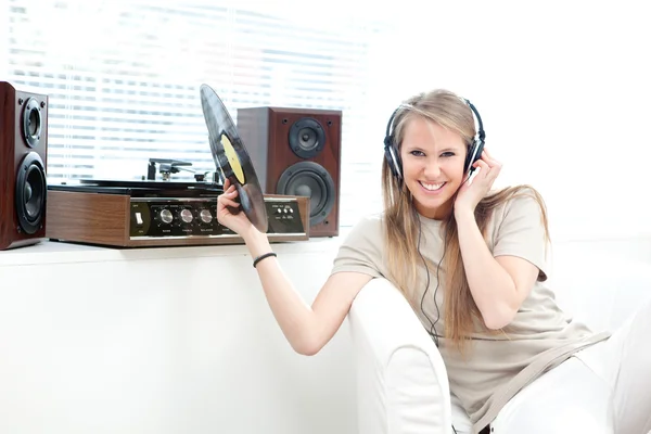 Mladá krásná žena poslouchat hudbu se záznamem v obývacím pokoji — Stock fotografie