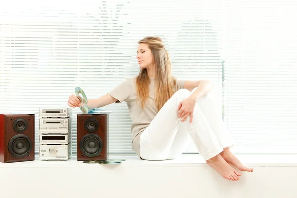 Giovane bella donna ascoltare musica con cd rom in un soggiorno — Foto Stock