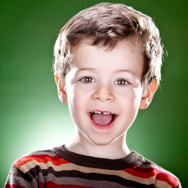 Улыбающийся блондин портрет ребенка на зеленом фоне — стоковое фото