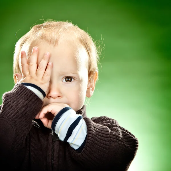 Lächeln blondes Kinderporträt auf grünem Hintergrund — Stockfoto