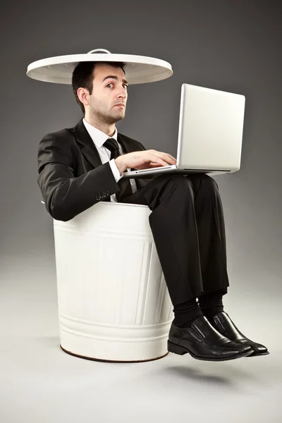 Funny businessman throw out in a bin on grey background — Stock Photo, Image