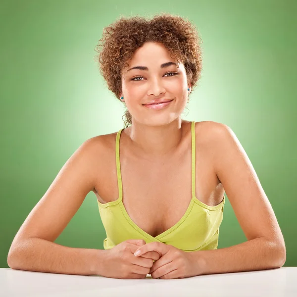 Красиве кучеряве волосся африканська дівчина посміхається портрет на зеленому фоні — стокове фото