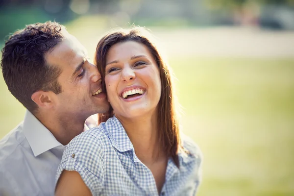 Junges brünettes Paar hat Spaß zusammen im Park — Stockfoto