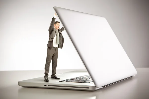 Little surprised businessman opening laptop cover at office — Stock Photo, Image