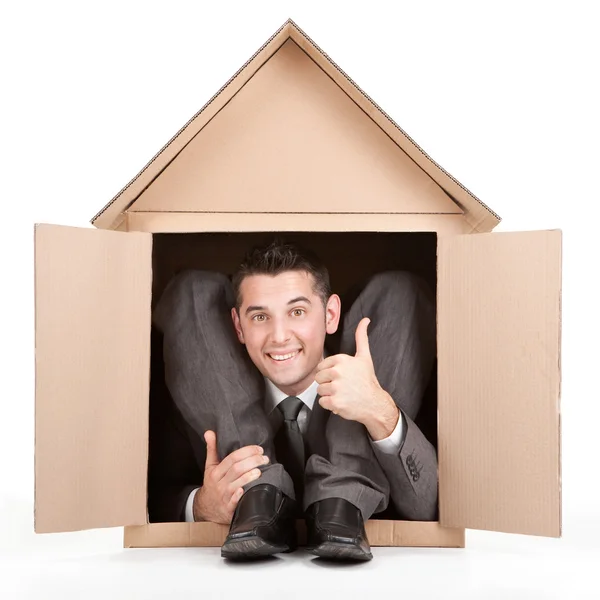 Elegante lachende gelukkig flexibele stilistiek zakenman in kartonnen huis — Stockfoto