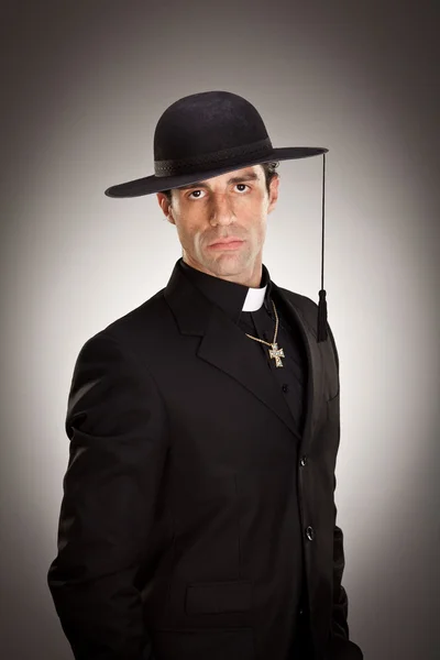 Young priest pray portrait on grey background — Stock Photo, Image