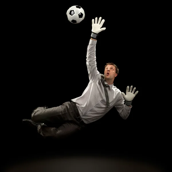 Businessman goalkeeper save a goal on black background — Stock Photo, Image