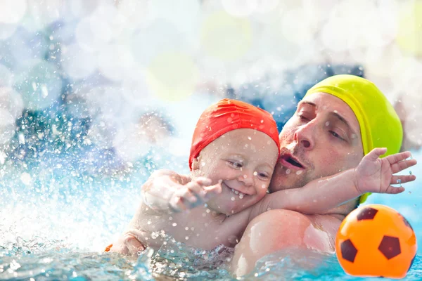 Anak dan ayah yang bahagia dengan topi kolam renang bersenang-senang di kolam renang — Stok Foto