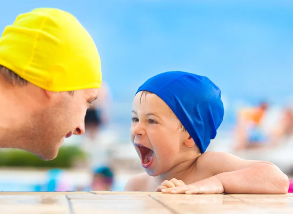 Feliz niño y papá con gorra de piscina divertirse en una piscina — Foto de Stock