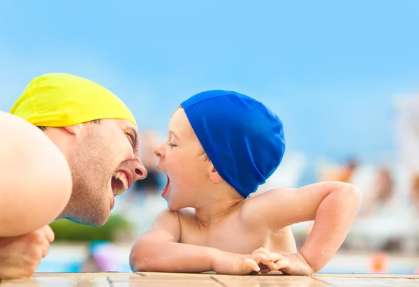 Feliz niño y papá con gorra de piscina divertirse en una piscina — Foto de Stock