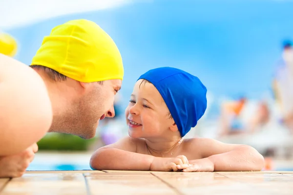 Happy child and dad with swimming pool cap have fun in a pool — Stock Photo, Image