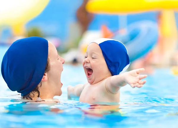 Happy child and mom with swimming pool cap have fun in a pool — Stock Photo, Image