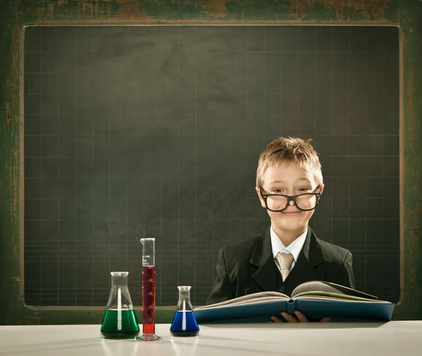 Jeune élégant étudiant intelligent en chimie ou scientifique pose sérieuse avec tableau noir — Photo