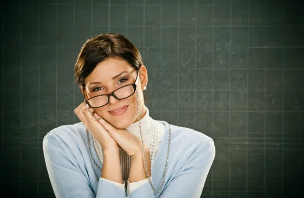 Krásný usměvavý mladý učitel s brýlemi a blackbouard — Stock fotografie