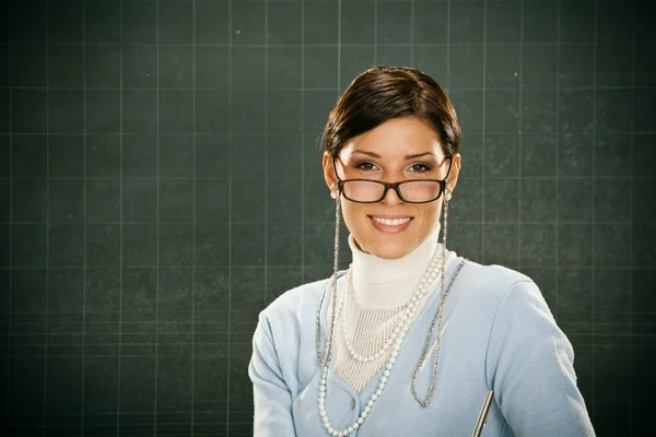 Hermosa joven profesora sonriente con gafas y blackbouard —  Fotos de Stock