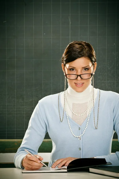 Szép mosolygó fiatal tanár, szemüveg és blackbouard — Stock Fotó