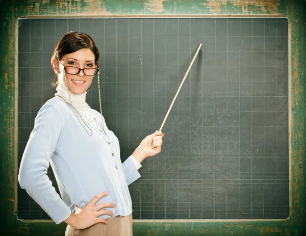 Hermosa joven profesora sonriente con gafas y blackbouard —  Fotos de Stock