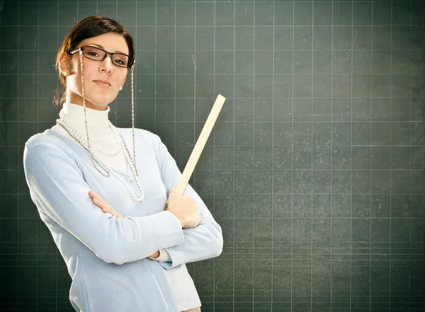 Улыбающаяся молодая учительница в очках и черном балахоне — стоковое фото