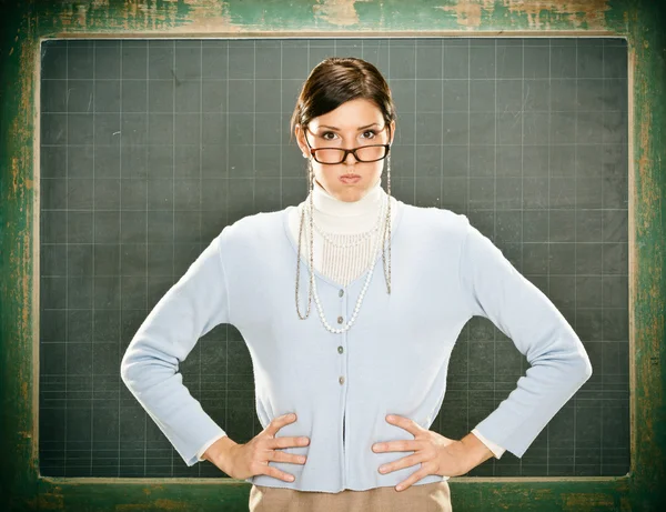 Krásné vážný mladý učitel s brýlemi a blackbouard — Stock fotografie