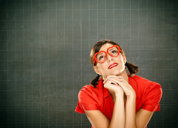 Sensuele dromerige jonge student rood gekleed met glazen en blackboard — Stockfoto