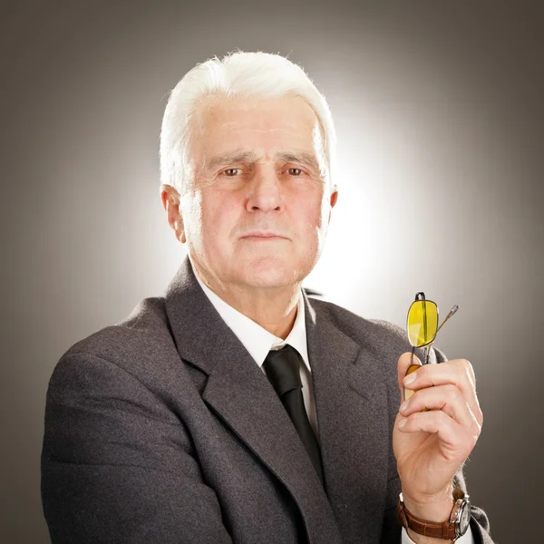 Senior businessman portrait with glasses isolated on grey — Stok fotoğraf