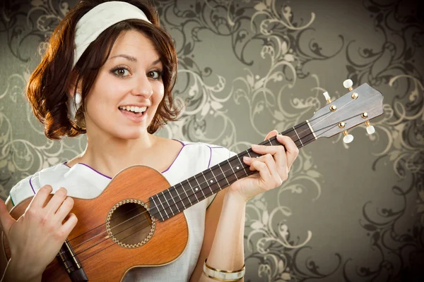 Vintage-Frau spielt Ukulele und singt auf Tapisserie Hintergrund — Stockfoto