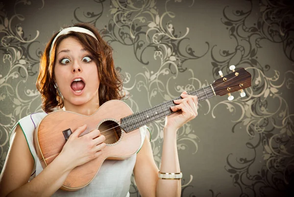 Vintage mulher joga ukulele e cantar em fundo de tapeçaria — Fotografia de Stock